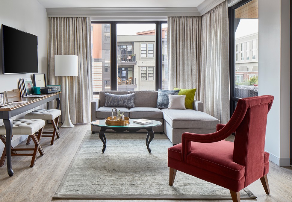 view of a modish living room area of a suite with big windows and a tv on the wall