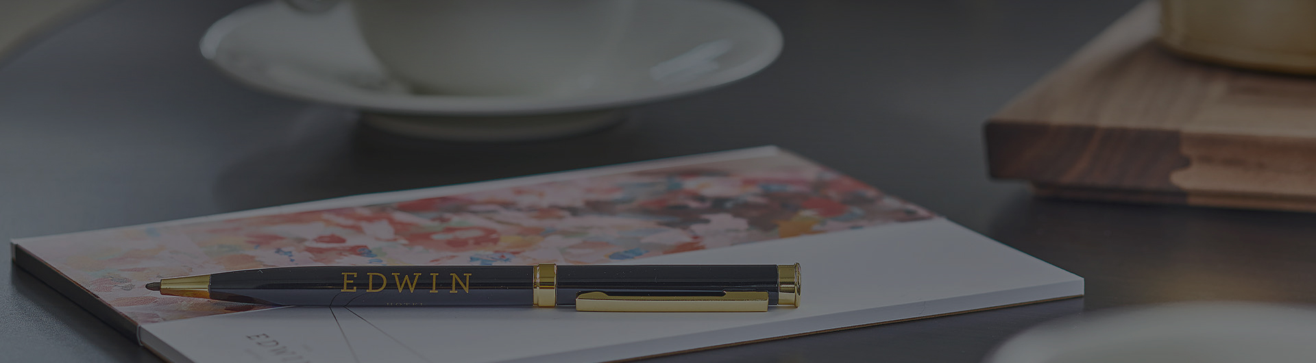 close up of a pen on a table with EDWIN on it sitting on a notebook