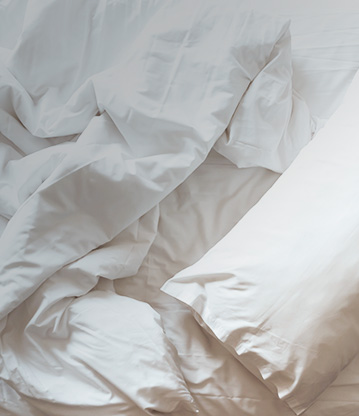 messy white sheets and a white pillow