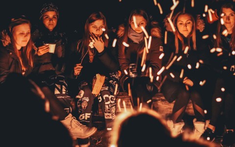 View of a group of young ladies on a wood fire at night 