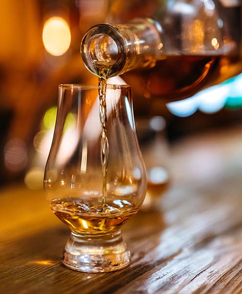 Close up of a person serving a bourbon shot