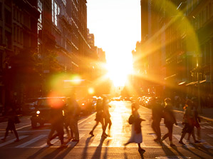people crossing the street and a strong sun light over the image