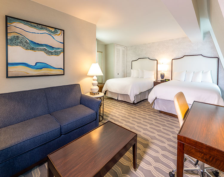 two beds and a sitting area in a room