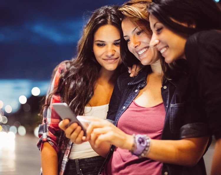 women looking at iPhone wearing casual clothes
