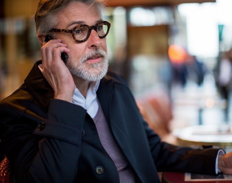 man answering a phone in a cafe