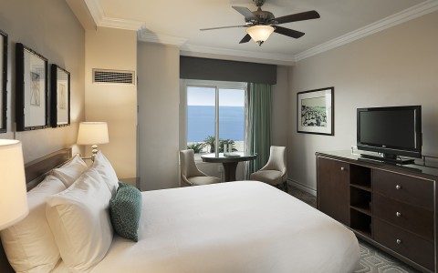 hotel bedroom with accent pillow and fan above