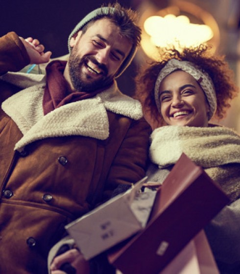 couple with shopping bags wearing winter clothing at night