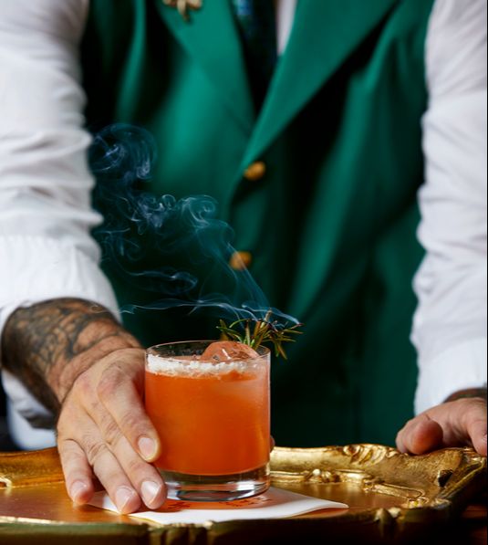 man serving drink on a platter