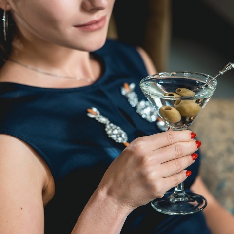 woman drinking out of a martini glass
