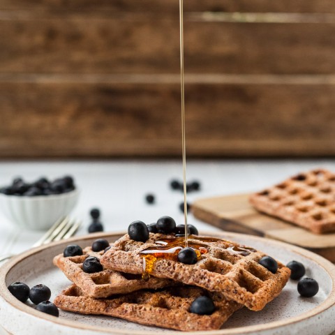 plate of waffles with syrup and blueberries 