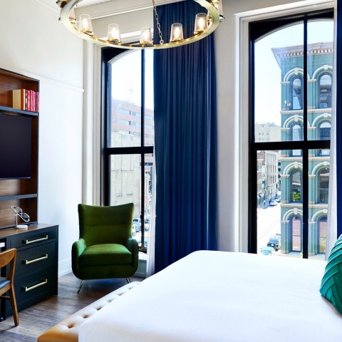a suite with a king bed and city view