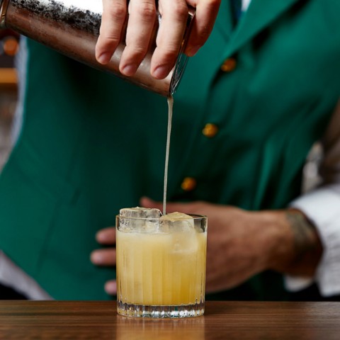 a bartender serving an alcoholic beverage