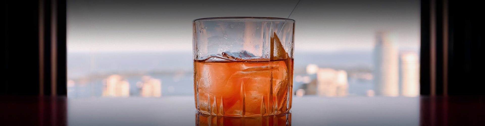 bourbon drink with a city skyline view in the background