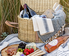 picnic basket filled with wines and cheeses