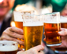 four people clinking beer pints