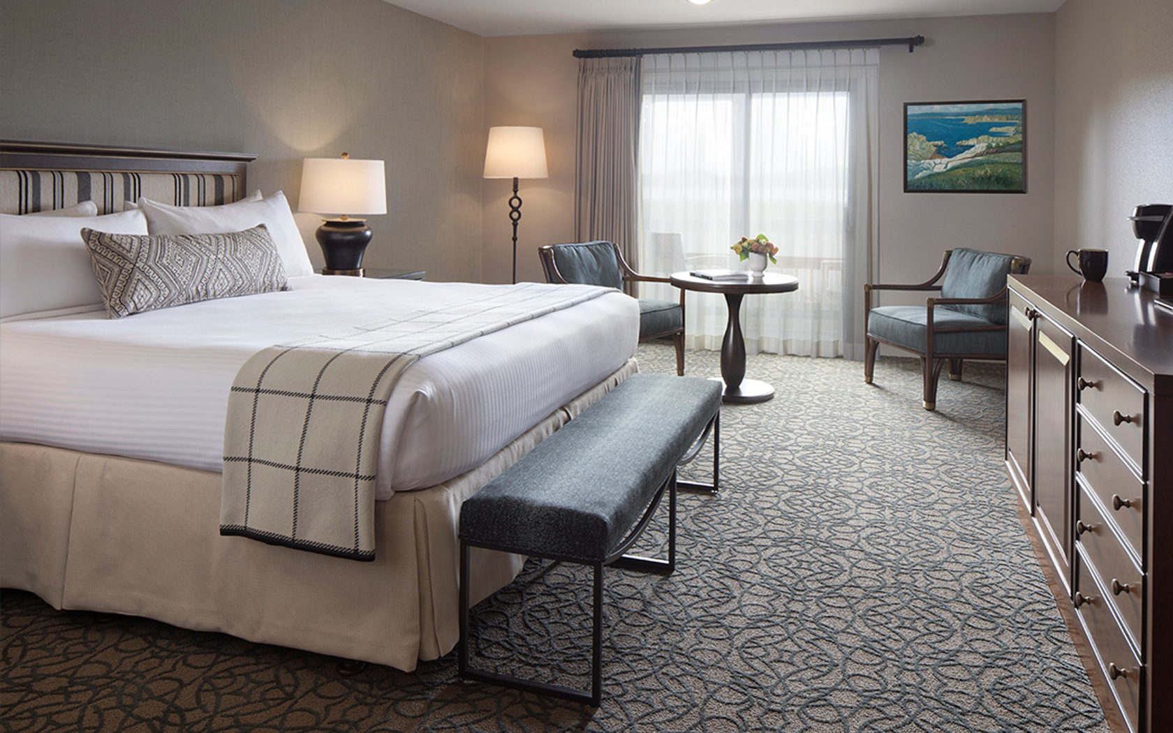 spacious hotel room with a large bed and seating area