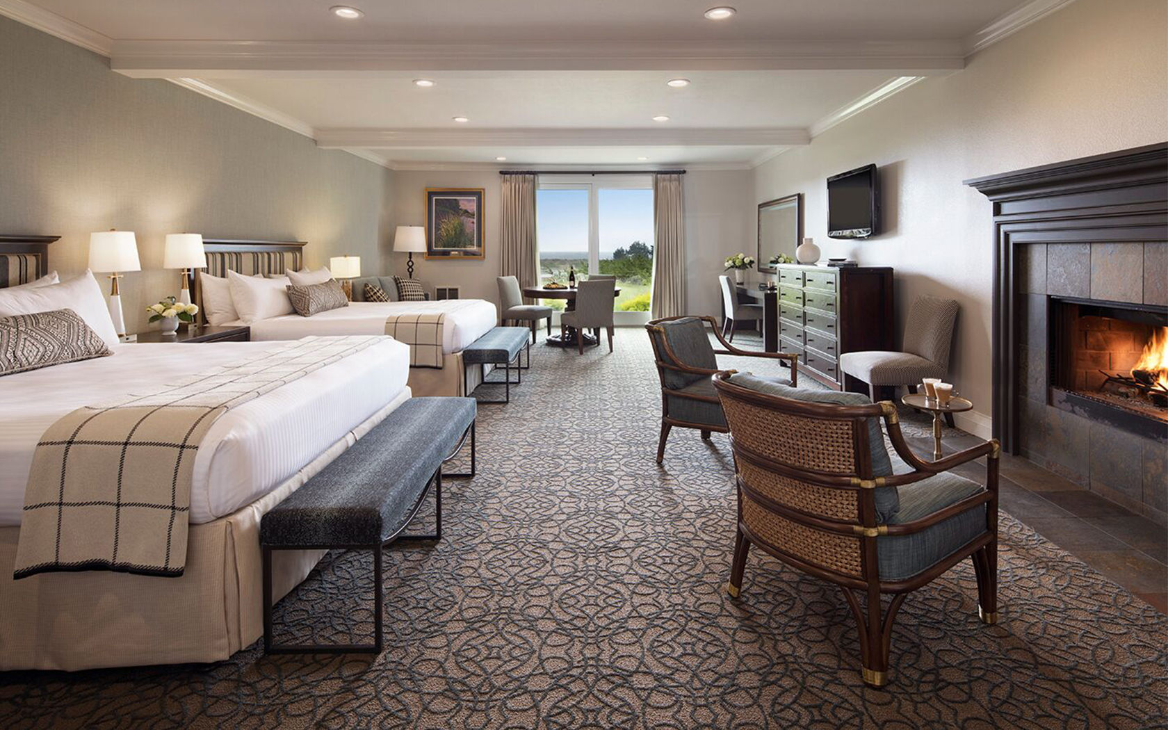 big hotel room with two double beds and a fire place
