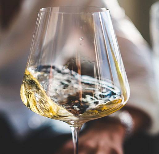 glass with white wine swirled in it