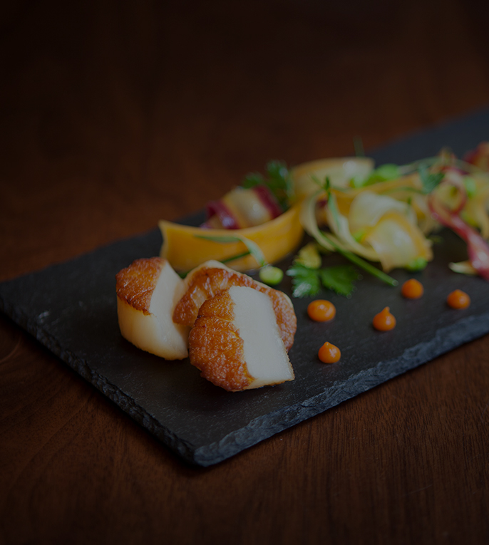 close up of seared scallops on a granite tray