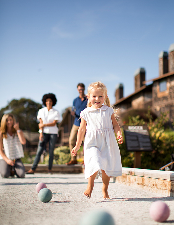 little girl running on bocce ball court