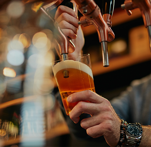 man pouring a beer from a tap