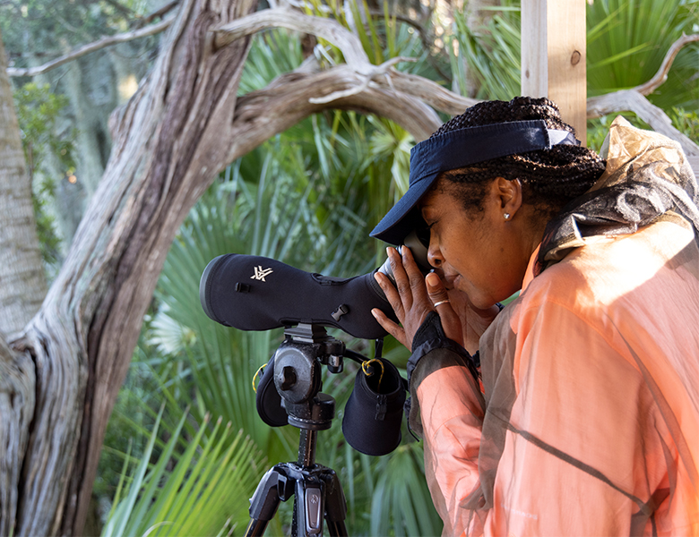 woman looking into telescope