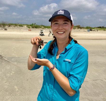 woman holding a baby sea turtle