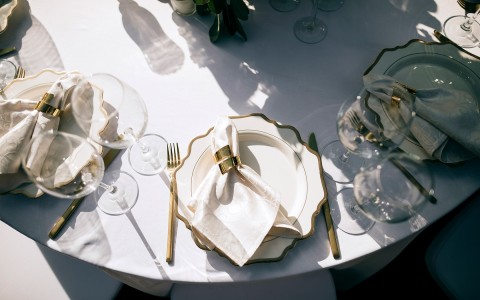 white and gold place setting on a white table 
