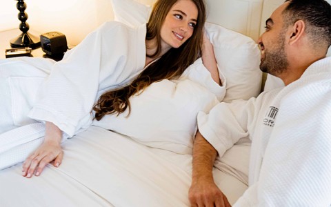 couple laying in bed together while in robes