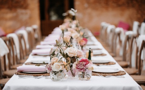 a variety of pink flowers and pink napkins for the decor of a wedding table