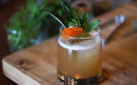 orange drink with herb garnish