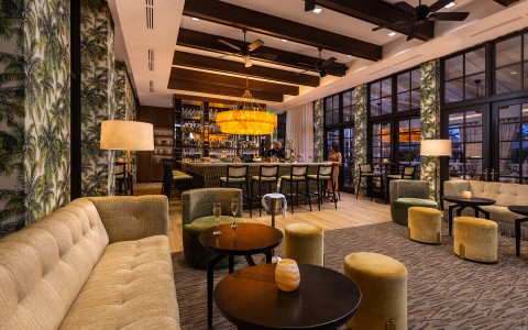 lounge and bar with low lighting and palm tree wall paper