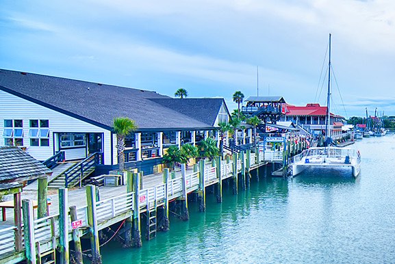 Beach houses with boats tied up on water