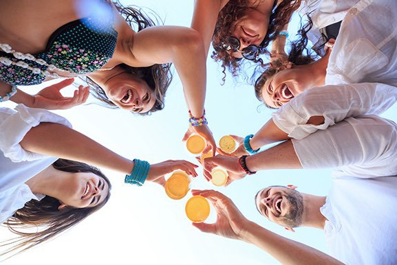 A group of friends smiling and having a drink outside