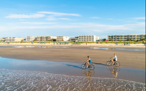 A couple riding bikes on the beach 