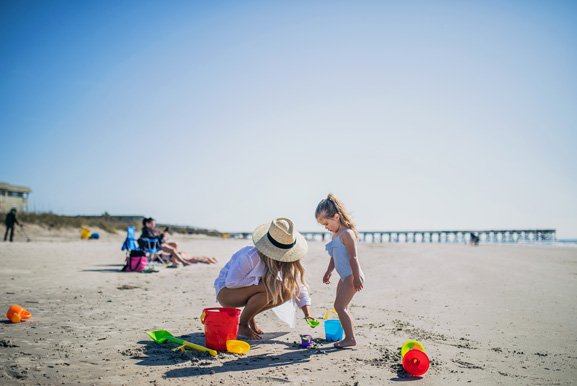 mom and daughter playing in the sand