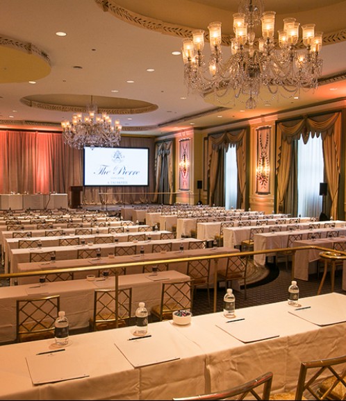 meeting space with long tables and chandeliers