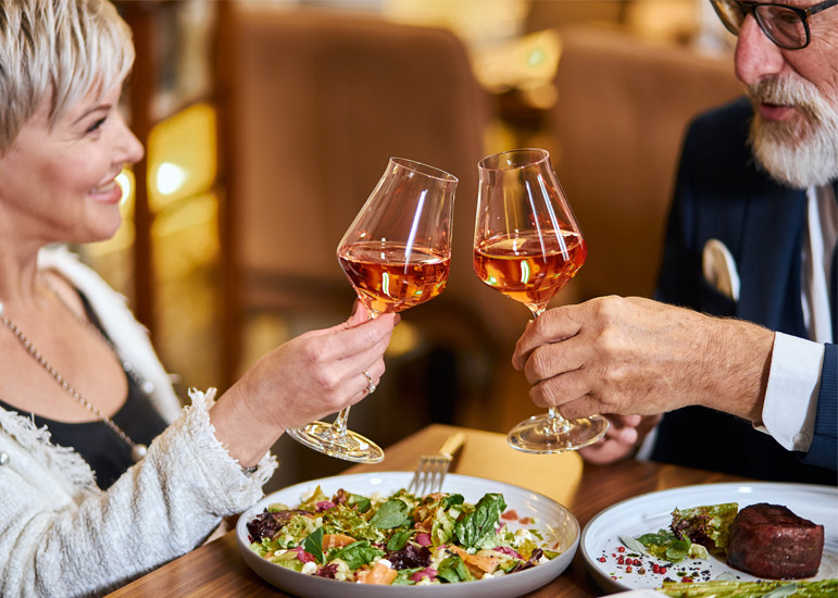 mature couple toasting their wine