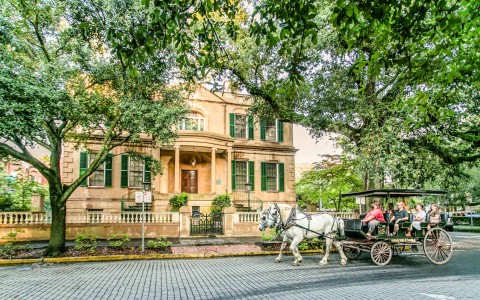horse drawn carriage ride in front of yellow building