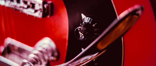 close up of the tuning dial on a red electric guitar
