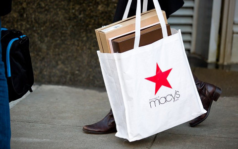 A woman holding a macy's shopping bag