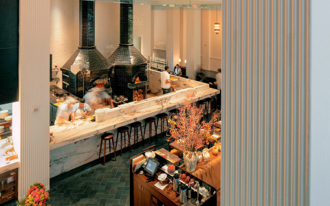 overtop view of the marble bar area and two black brick ovens at a restaurant