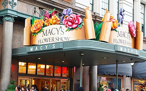 a macy's flower show sign on top of an awning outside the store