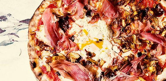 pizza topped with ham and an egg