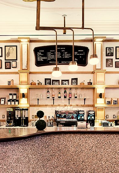 a coffee shop counter with gold accents and hanging lights