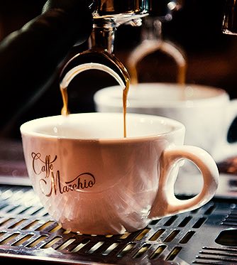 a coffee mug under an espresso machine
