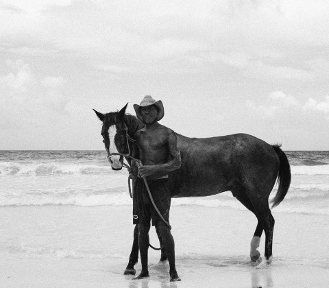A man with a horse at a seashore 