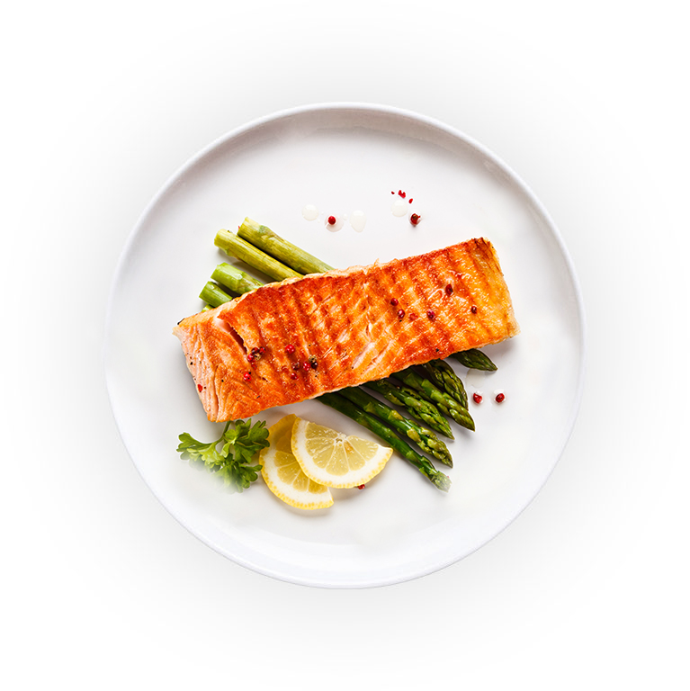 Top view of a plate with salmon, asparagus and lemon slices