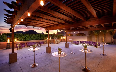 scottsdale plaza dimmed lighting area with tables and small lit candles and purple couches