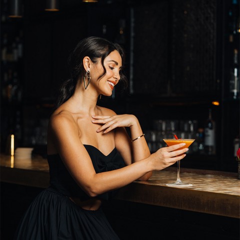 lady wearing black dress having a cocktail 